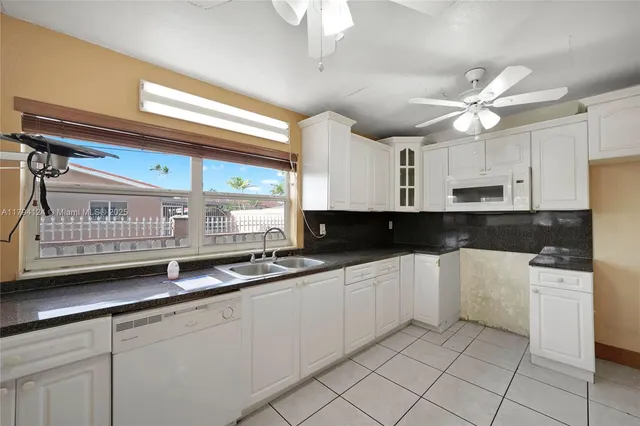 a kitchen with a sink window and cabinets