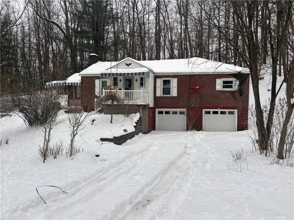 a front view of a house with a yard covered in snow