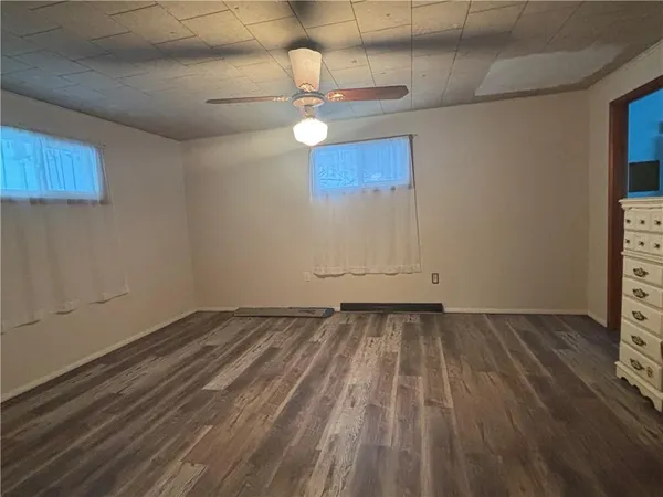 a view of a room with wooden floor and ceiling fan