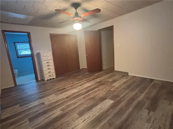 an empty room with wooden floor and window