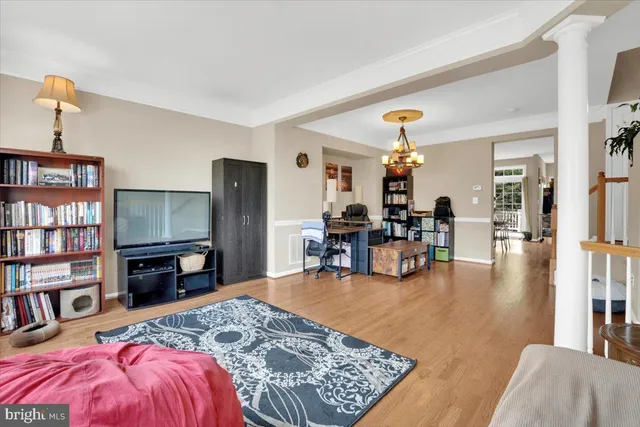 a living room with furniture and a dining table with bookshelf