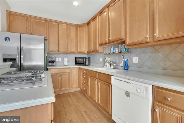a kitchen with stainless steel appliances granite countertop a refrigerator sink and white cabinets