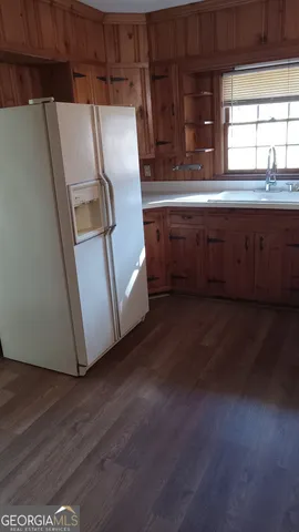 a kitchen with a refrigerator sink and cabinets