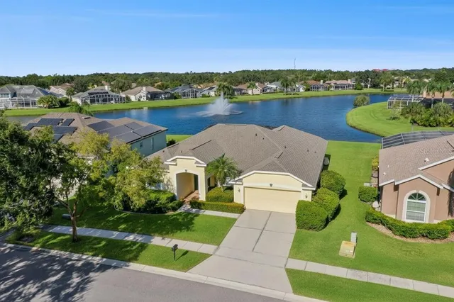 an aerial view of a house with a garden and lake view