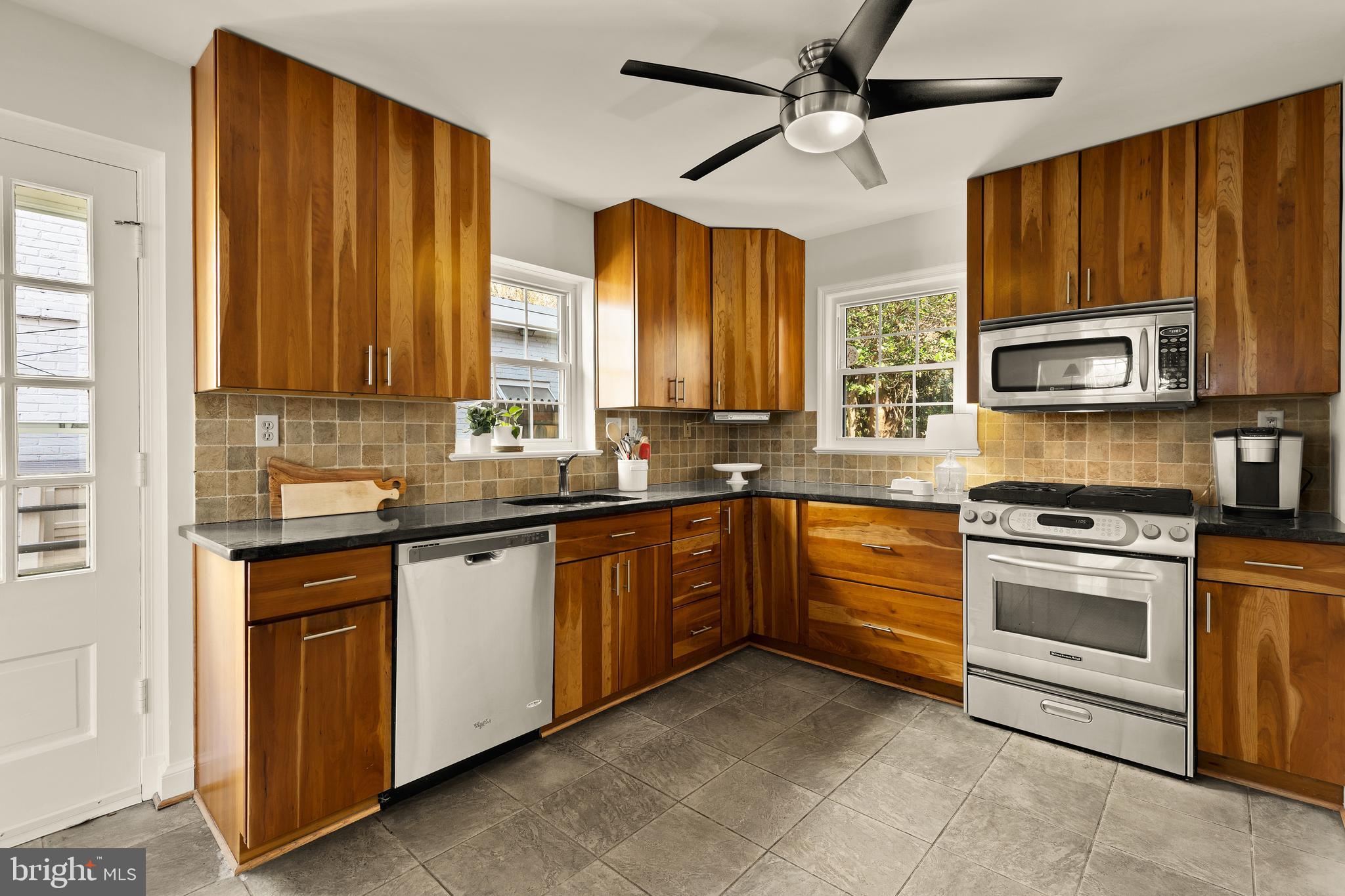 5705 MacArthur Boulevard Northwest Washington, DC 20016 - Photo 9 of 40 a kitchen with stainless steel appliances granite countertop a stove sink microwave and cabinets