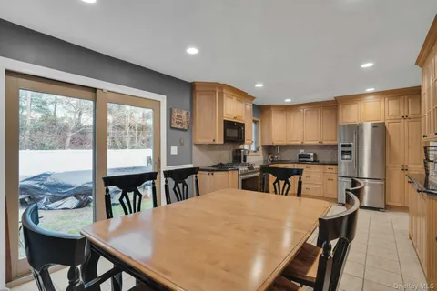 a kitchen with refrigerator dining table and chairs