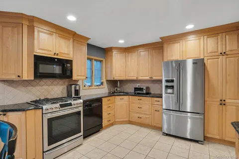 a kitchen with stainless steel appliances granite countertop a refrigerator stove microwave and sink
