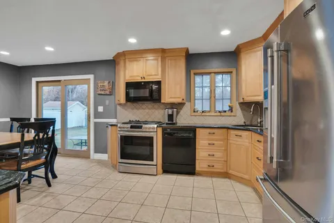 a kitchen with stainless steel appliances granite countertop a stove a sink and a refrigerator