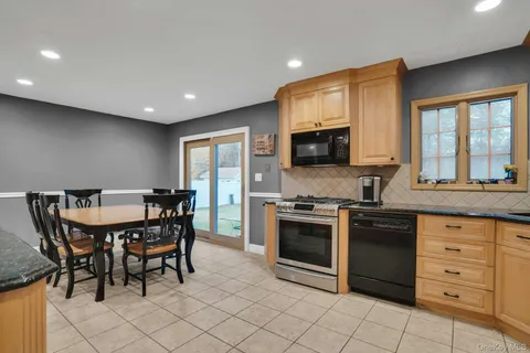 a kitchen with stainless steel appliances granite countertop a stove a sink a microwave and a refrigerator