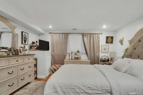 a bedroom with a bed a couch and a flat tv screen