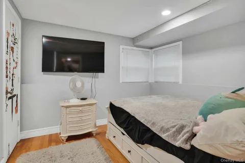 a living room with a bed furniture and a flat screen tv