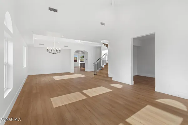 a kitchen with stainless steel appliances granite countertop a sink a stove and a wooden floors