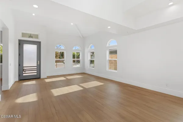 a view of a livingroom with wooden floor and stairs