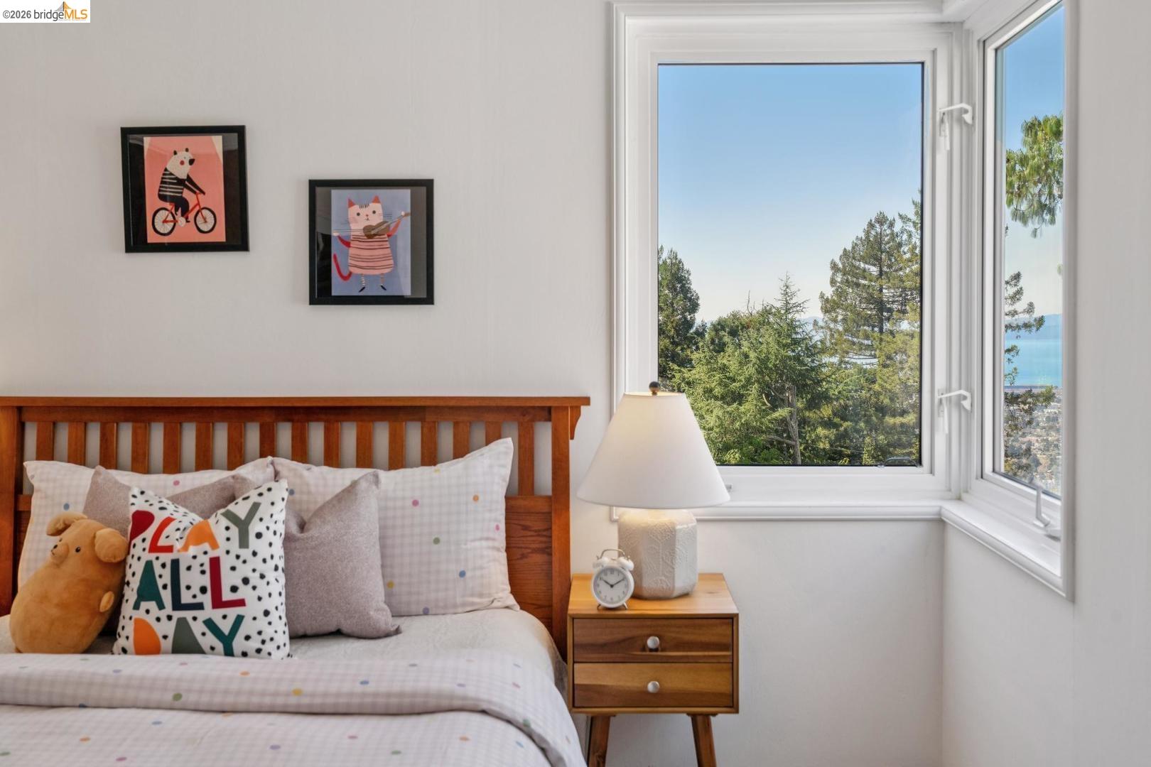 155 Avenida Drive Berkeley, CA 94708 - Photo 35 of 86 White wall finishes, natural wood headboard, corner window configuration, framed wall art, and a wood-finish nightstand