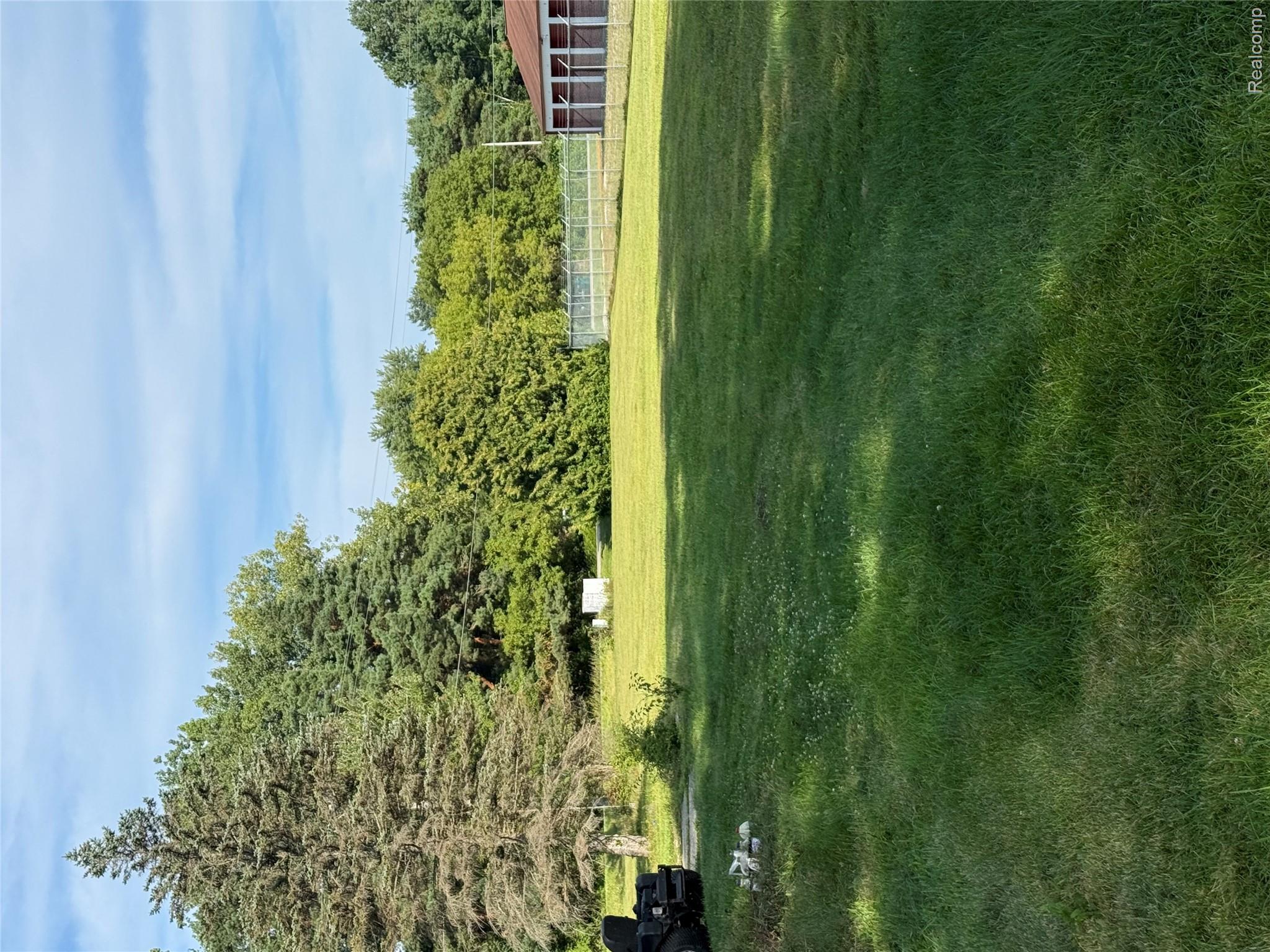 6526 State Road Millington, MI 48746 - Photo 27 of 29 Expansive grassy area with mature trees and a fenced perimeter