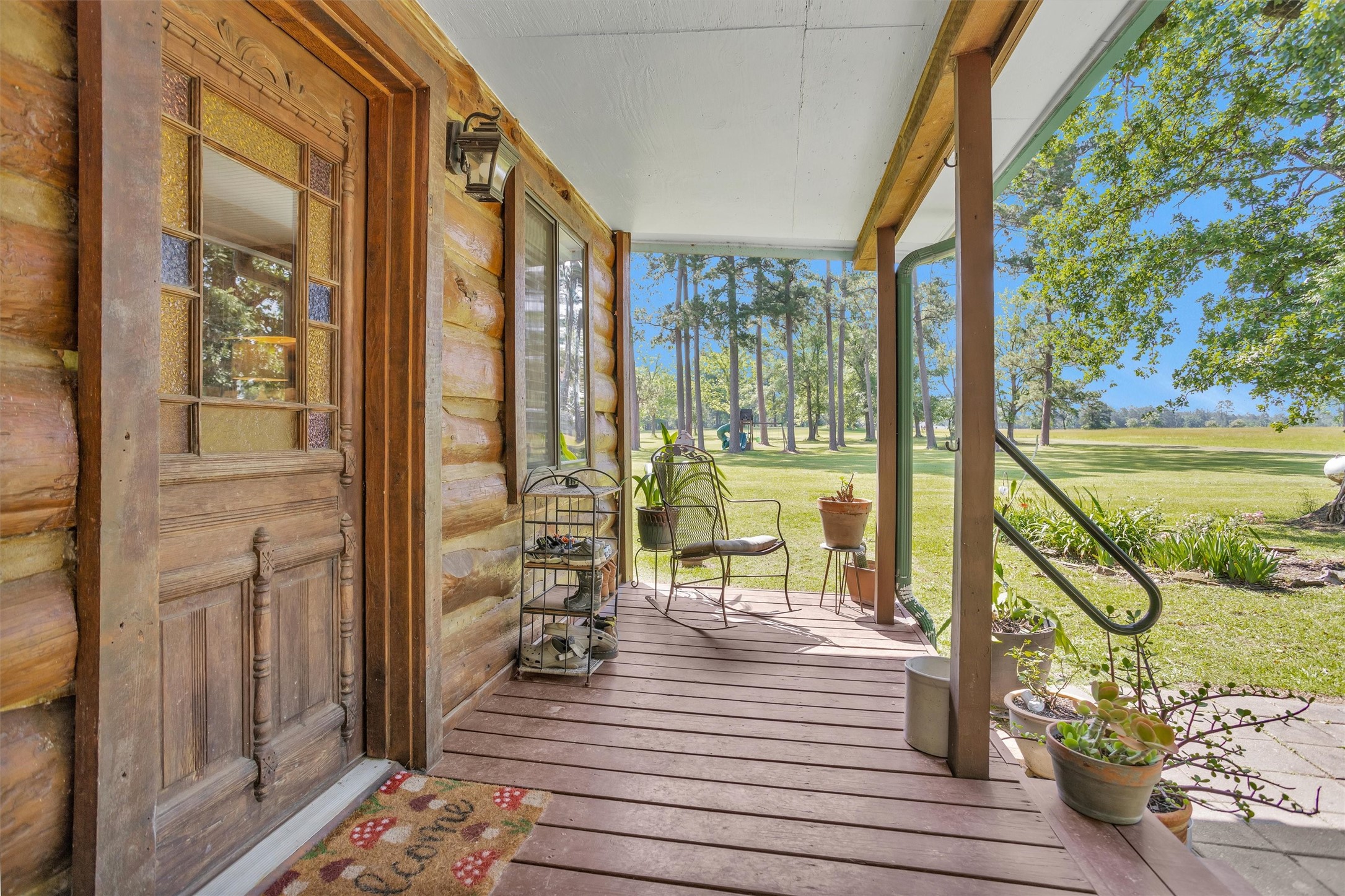 1356 Pegoda Ranch Road Groveton, TX 75845 - Photo 31 of 44 a view of a balcony with wooden floor and bench next to a yard