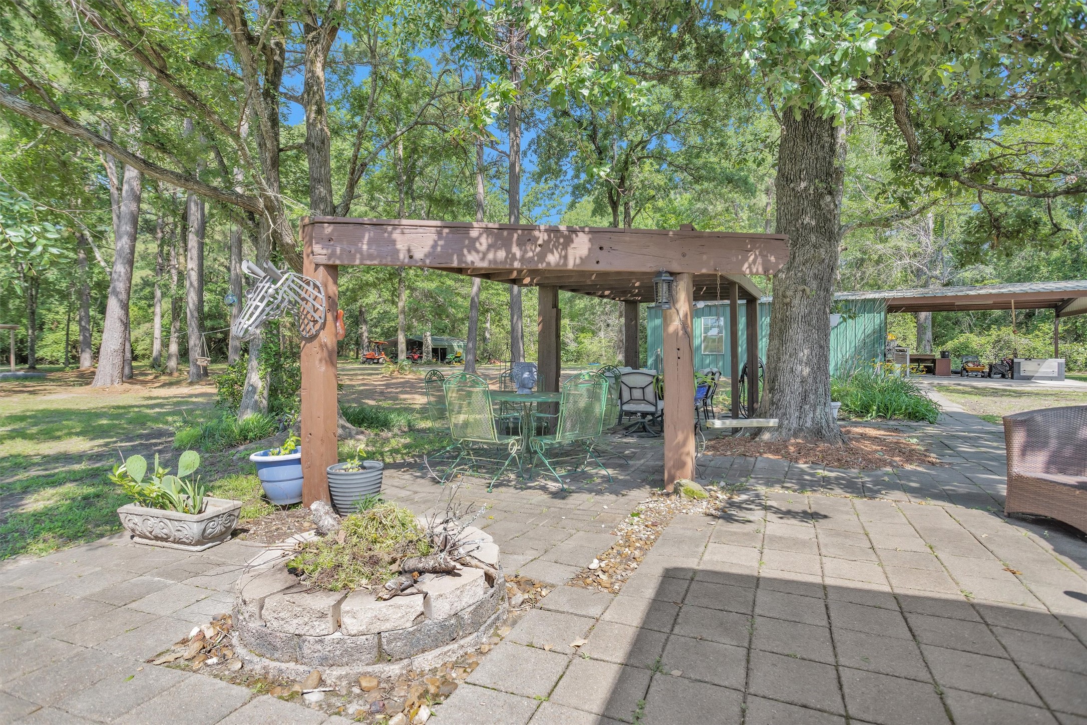 1356 Pegoda Ranch Road Groveton, TX 75845 - Photo 32 of 44 a backyard of a house with fountain table and chairs