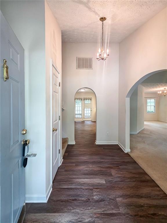 355 Austin Way Auburn, GA 30011 - Photo 2 of 19 a view of a hallway with wooden floor and chandelier