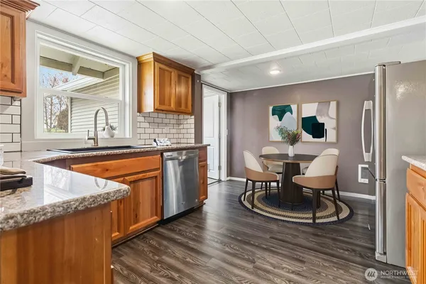 a kitchen with granite countertop a sink stove and cabinets