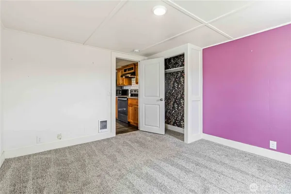 an empty room with closet and a window