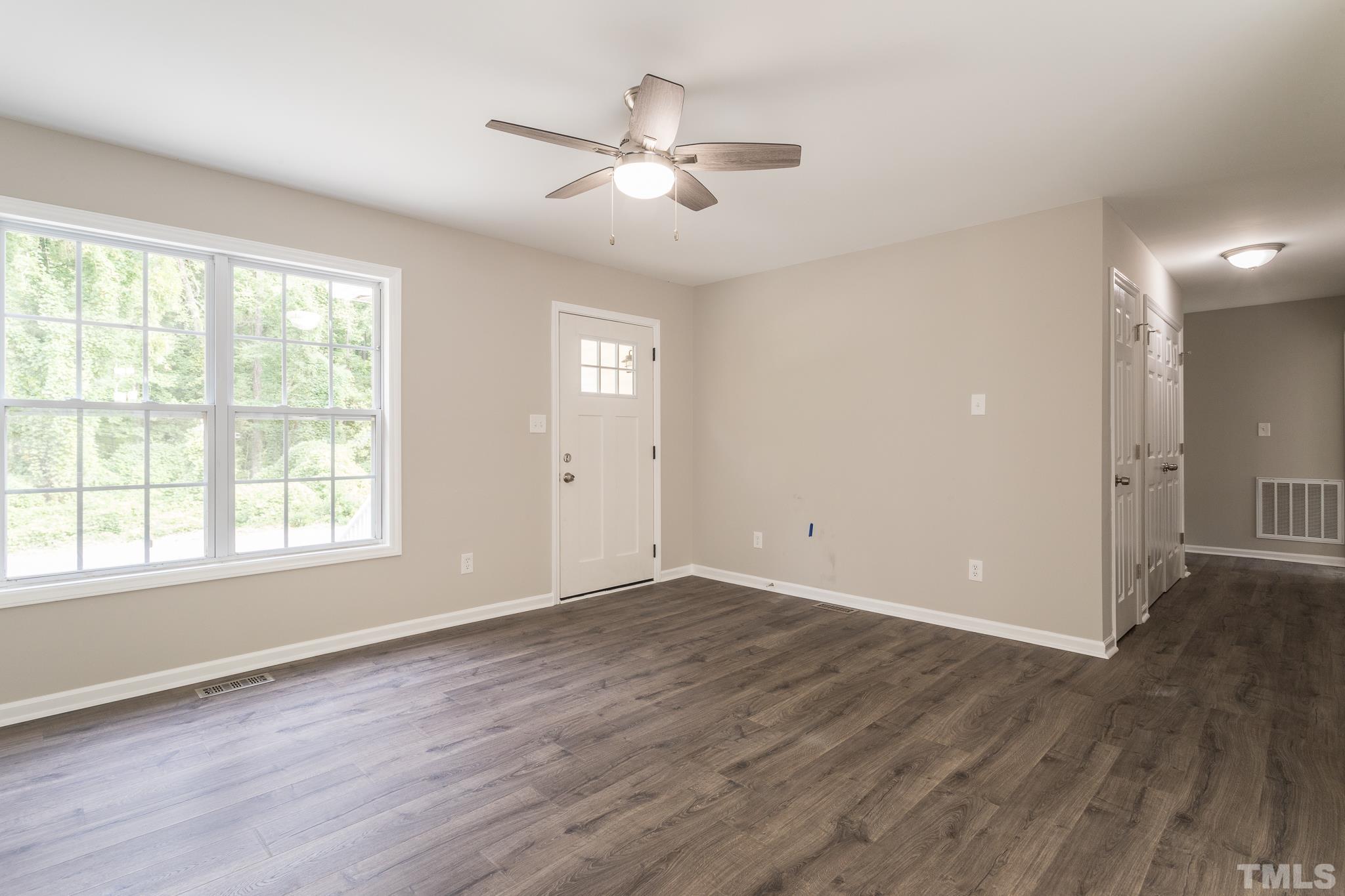 1807 South Roxboro Street Durham, NC 27707 - Photo 12 of 27 an empty room with wooden floor chandelier fan and windows