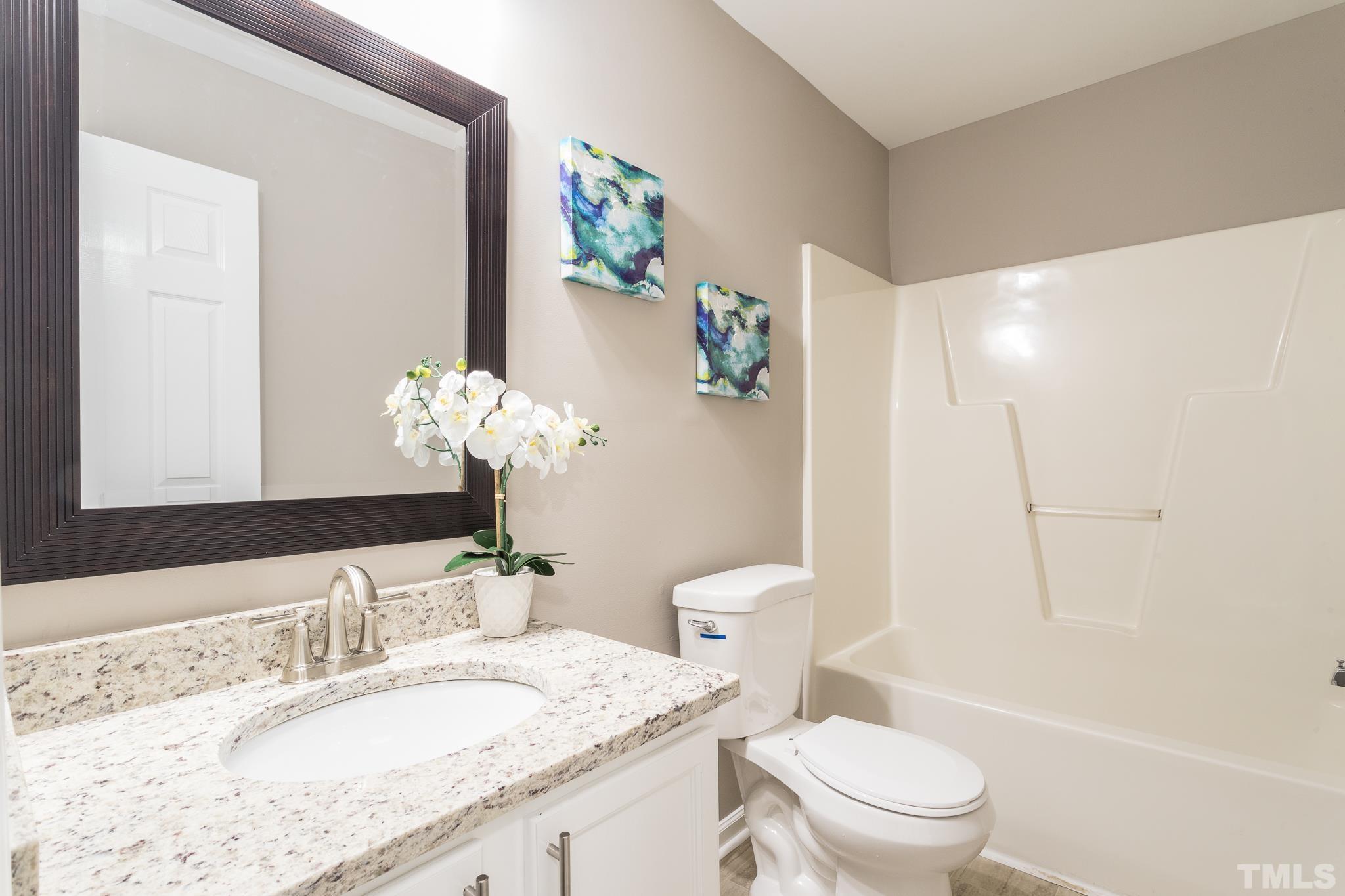 1807 South Roxboro Street Durham, NC 27707 - Photo 20 of 27 a bathroom with a granite countertop sink a toilet and a mirror