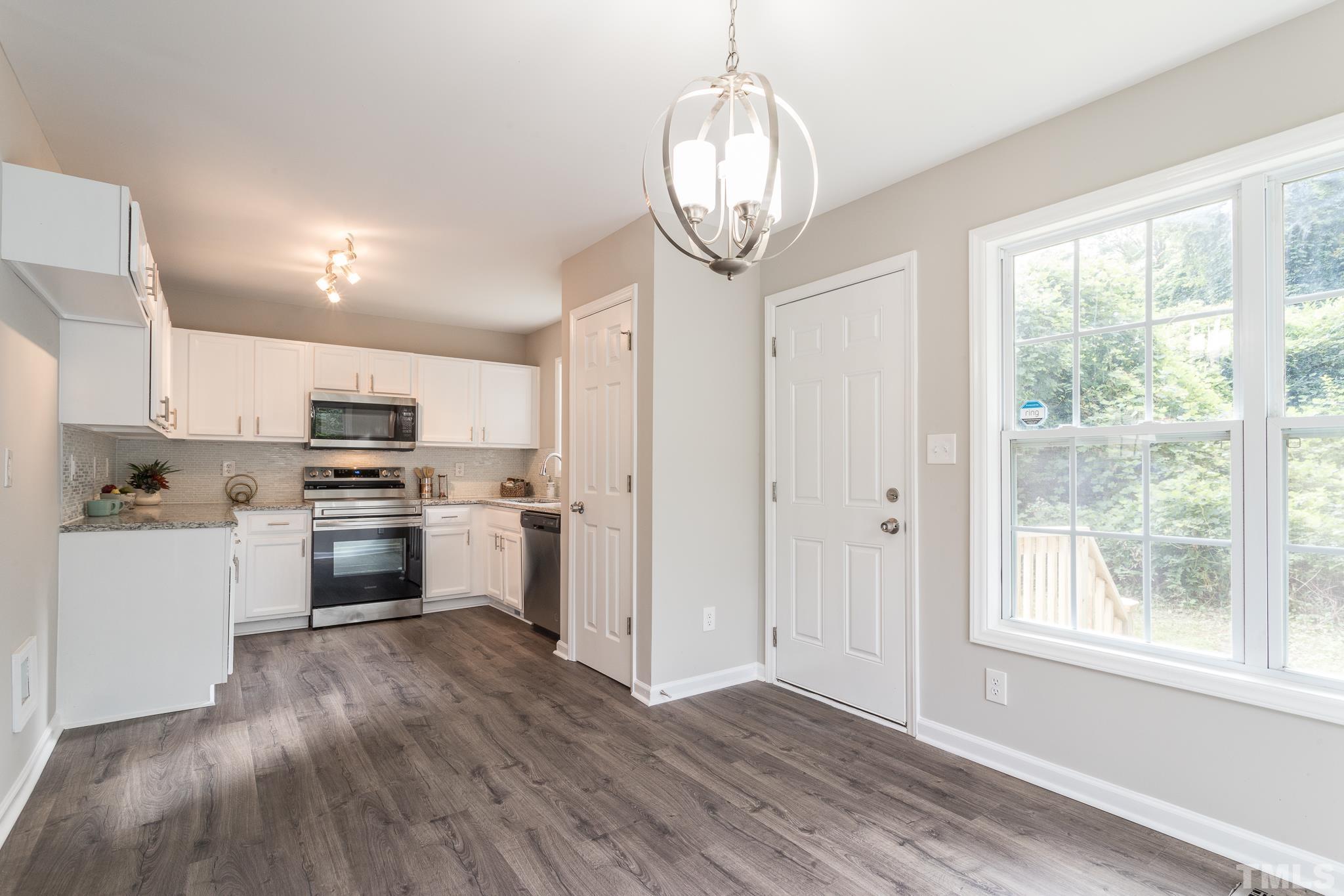 1807 South Roxboro Street Durham, NC 27707 - Photo 3 of 27 a kitchen with white cabinets and stainless steel appliances