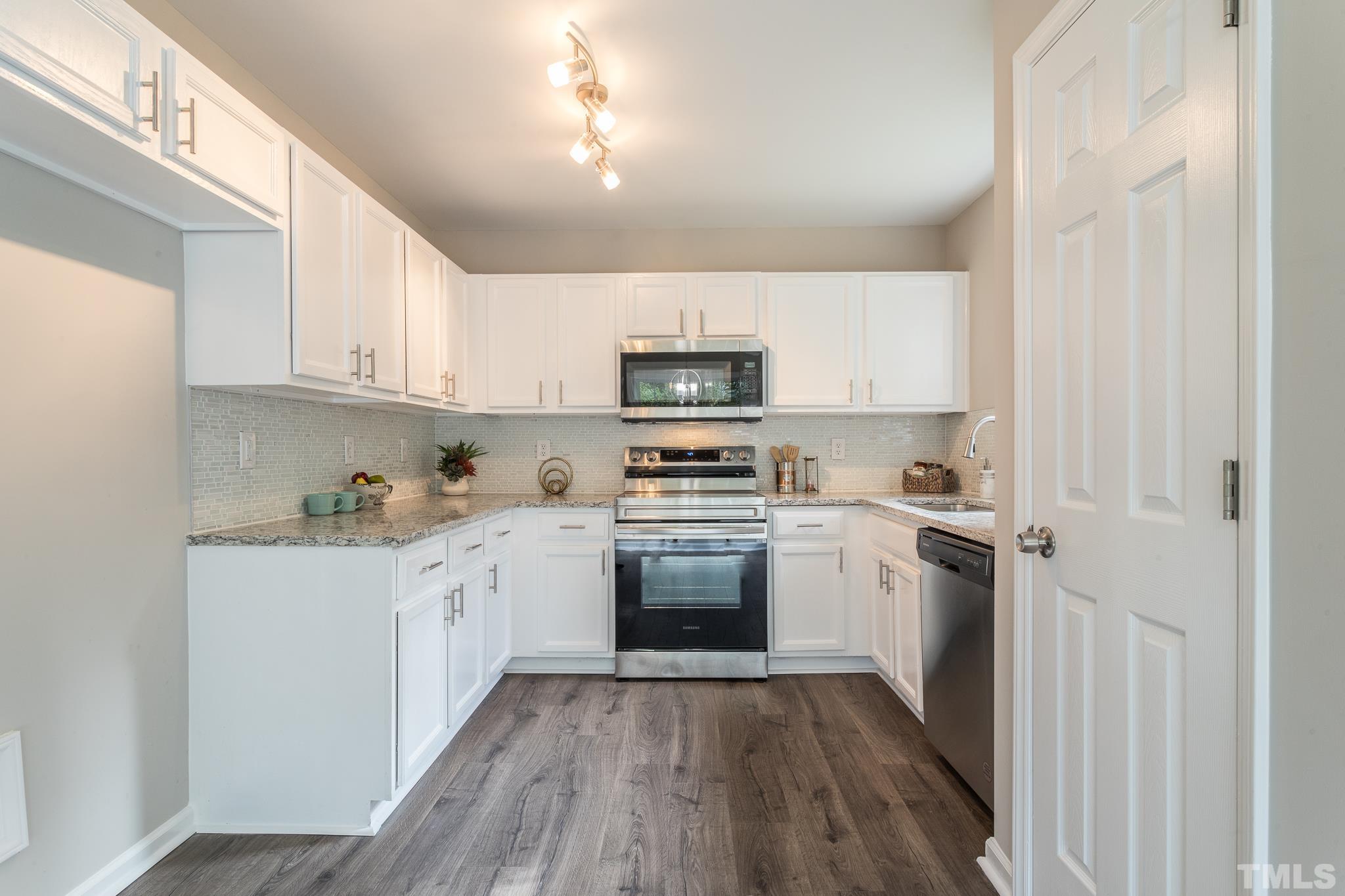 1807 South Roxboro Street Durham, NC 27707 - Photo 5 of 27 a kitchen with granite countertop white cabinets and stainless steel appliances