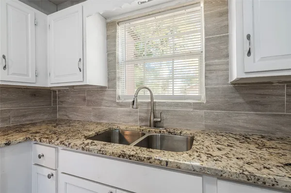 a kitchen with granite countertop a sink and a window