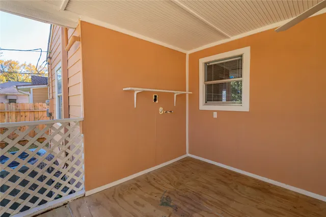 a view of a hallway with wooden floor and a window