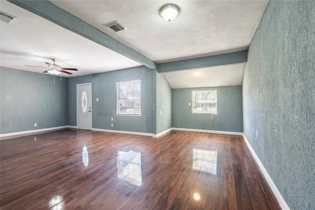 a view of empty room with wooden floor and window
