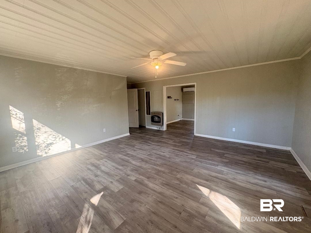 9330 Pinewood Avenue, Unit S 1 2 3 4 Elberta, AL 36530 - Photo 5 of 12 Empty room with heating unit, wood finished floors, a ceiling fan, and crown molding