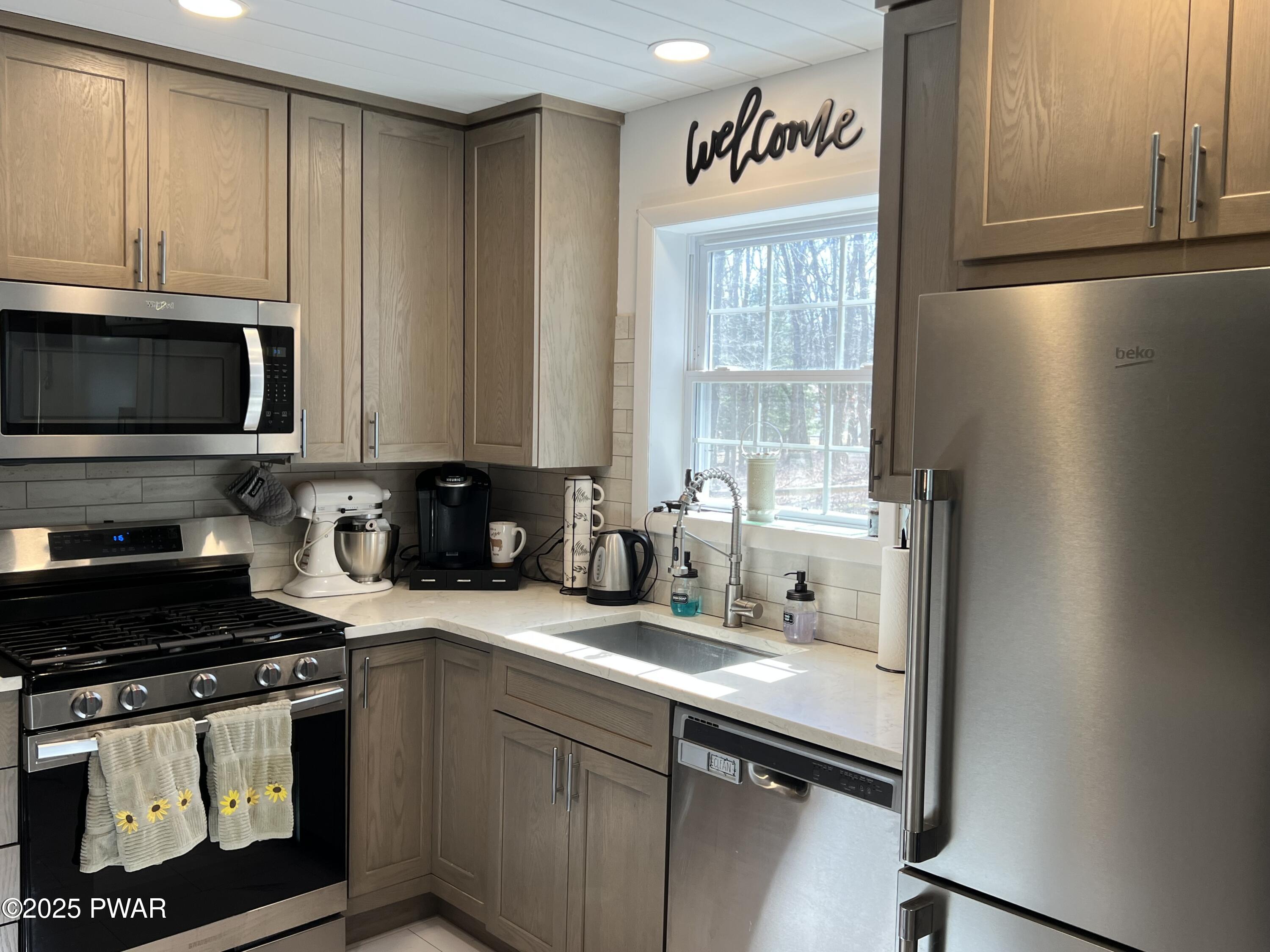 119 Rodeo Drive Hawley, PA 18428 - Photo 11 of 34 a kitchen with stainless steel appliances granite countertop a stove a sink and a microwave