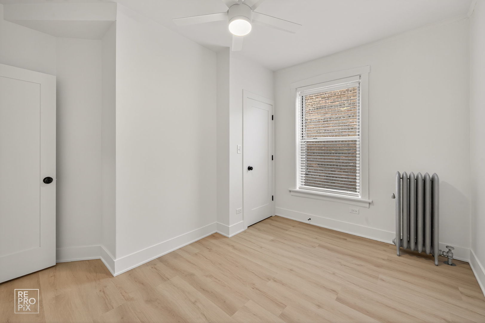 6977 North Bell Avenue, Unit 3 Chicago, IL 60645 - Photo 11 of 15 an empty room with wooden floor and a window