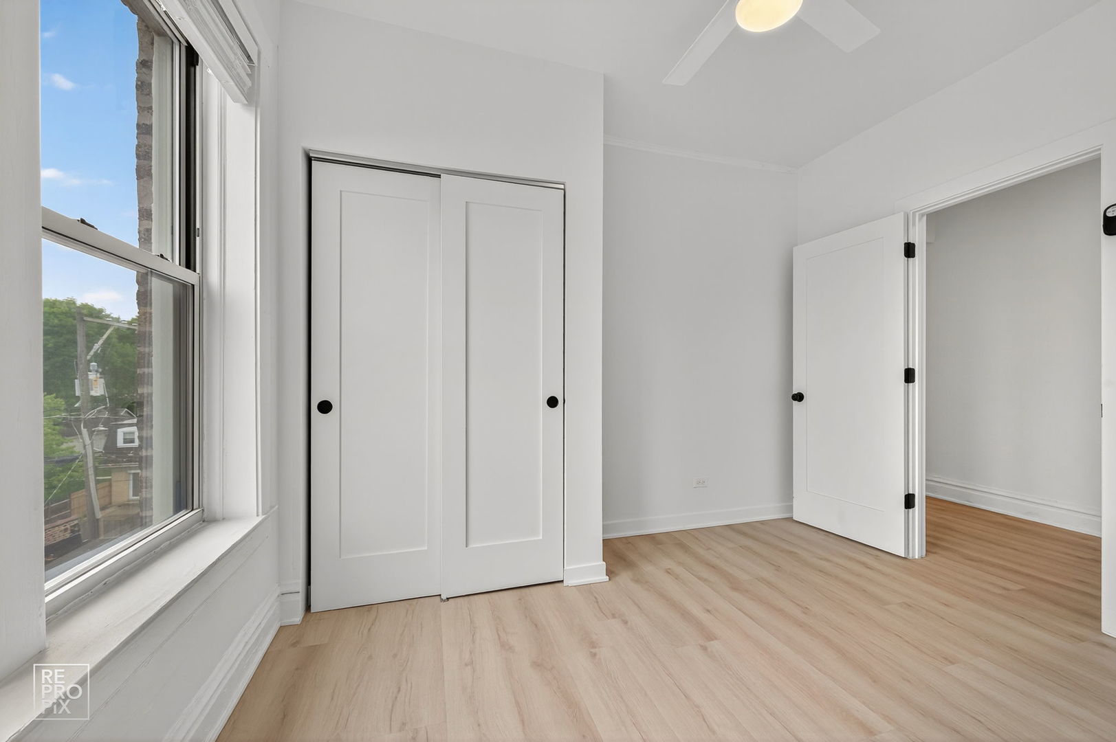 6977 North Bell Avenue, Unit 3 Chicago, IL 60645 - Photo 9 of 15 a view of an empty room with wooden floor and a window
