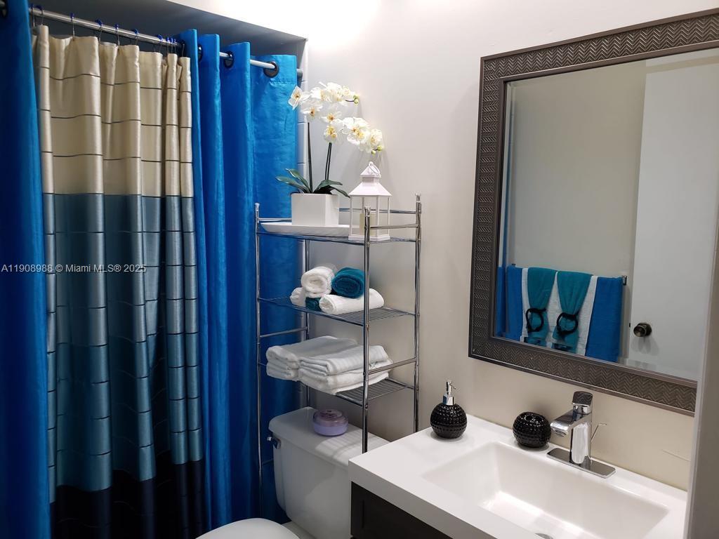 13792 Southwest 149th Cir Lane, Unit 3 Miami, FL 33186 - Photo 6 of 7 a bathroom with a sink and a mirror