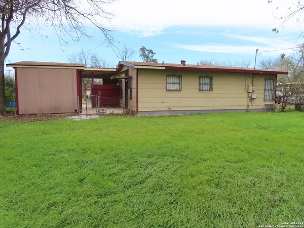 a view of a backyard with table and chairs and a barbeque