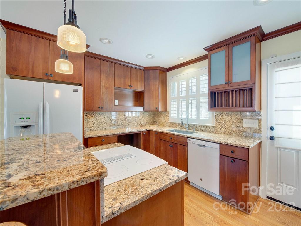 1007 Andover Road, Unit A3 Charlotte, NC 28211 - Photo 11 of 38 a kitchen with kitchen island granite countertop wooden cabinets a stove and a sink