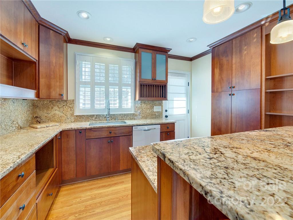 1007 Andover Road, Unit A3 Charlotte, NC 28211 - Photo 13 of 38 a kitchen with granite countertop wooden cabinets a sink and dishwasher