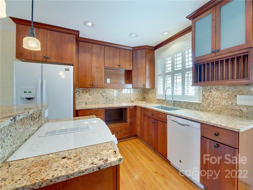 1007 Andover Road, Unit A3 Charlotte, NC 28211 - Photo 14 of 38 a kitchen with stainless steel appliances granite countertop a sink stove and wooden cabinets