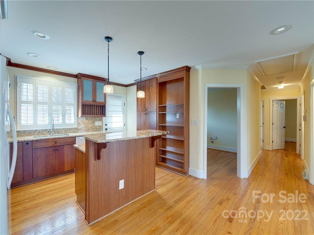 1007 Andover Road, Unit A3 Charlotte, NC 28211 - Photo 10 of 38 a kitchen with kitchen island granite countertop wooden floors and wide window