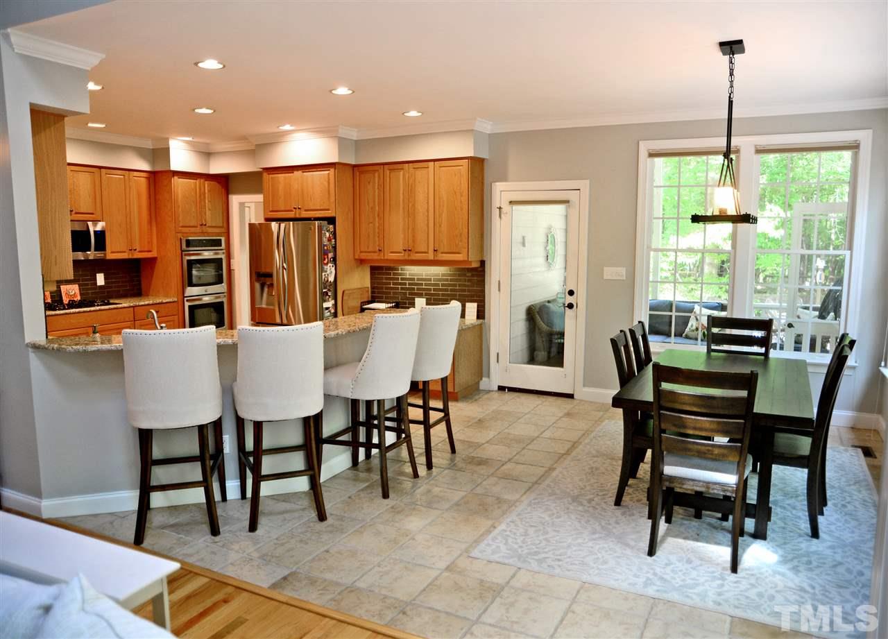 5800 Stone Canyon Court Raleigh, NC 27613 - Photo 6 of 30 Transition from kitchen to eat-in area with ease! Large enough to accommodate your favorite family table! In addition, enjoy the counter seating, built in desk & spacious kitchen. Take your coffee or cocktail to the screened porch just out the side door!