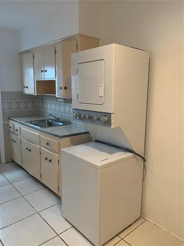 a utility room with cabinets washer and dryer