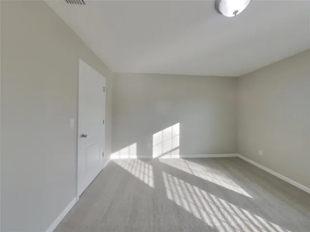 a view of a room with wooden floor and a window