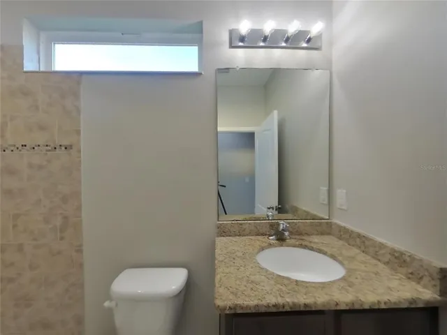 a bathroom with a granite countertop sink and a mirror