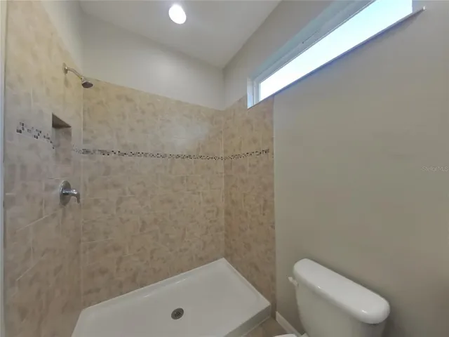 a bathroom with a toilet and a shower