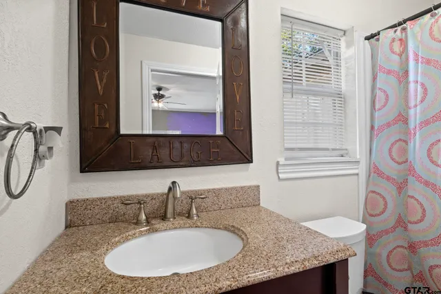 a bathroom with a granite countertop sink and a mirror