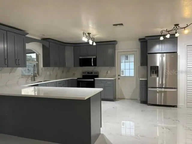 a kitchen with kitchen island a sink stainless steel appliances and counter space