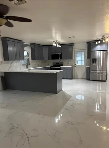 a kitchen with kitchen island a sink and a stove top oven