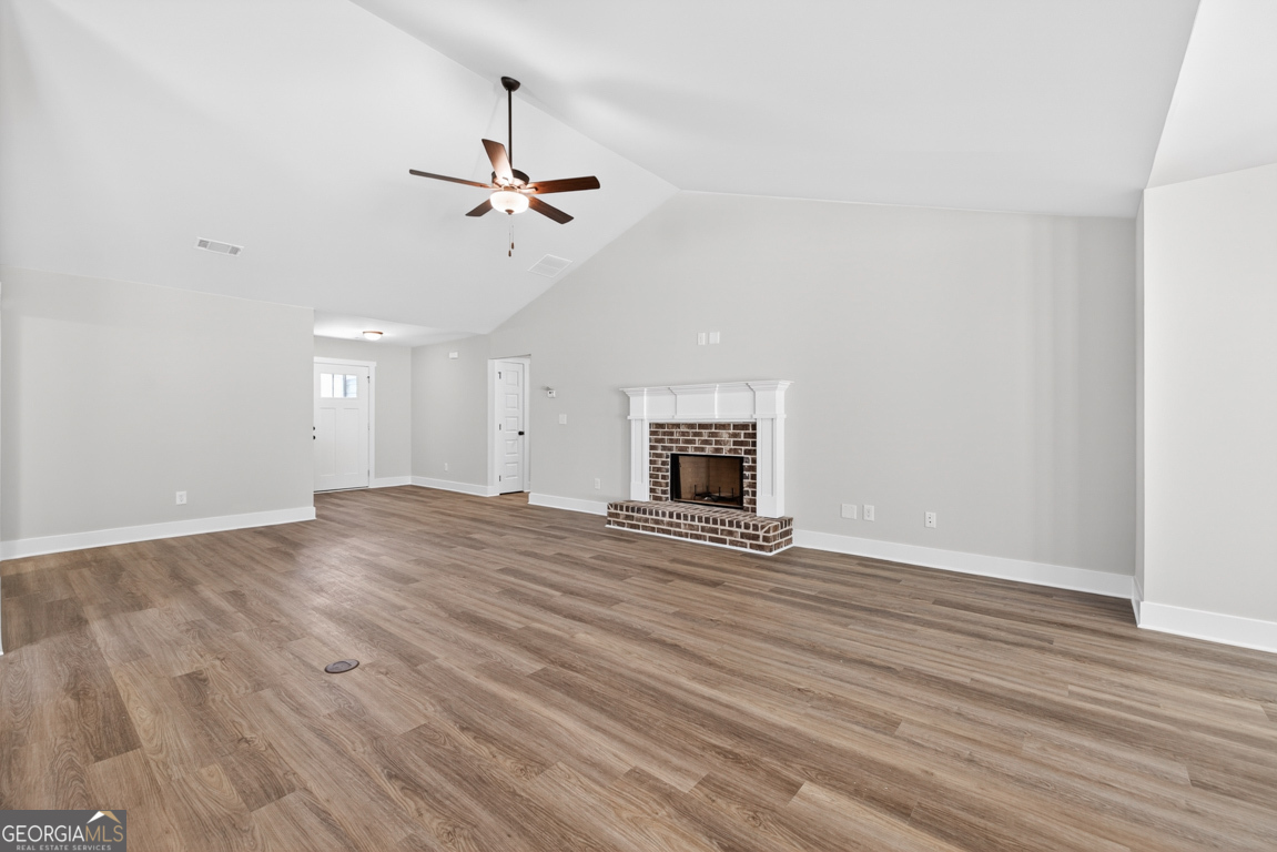 206 Airport Road, Unit 11 Canon, GA 30520 - Photo 9 of 34 an empty room with wooden floor fireplace and windows